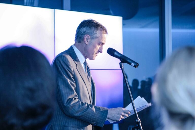 A speaker presents at a corporate event, creating a dynamic atmosphere captured in IMG_1840-1920w photography.